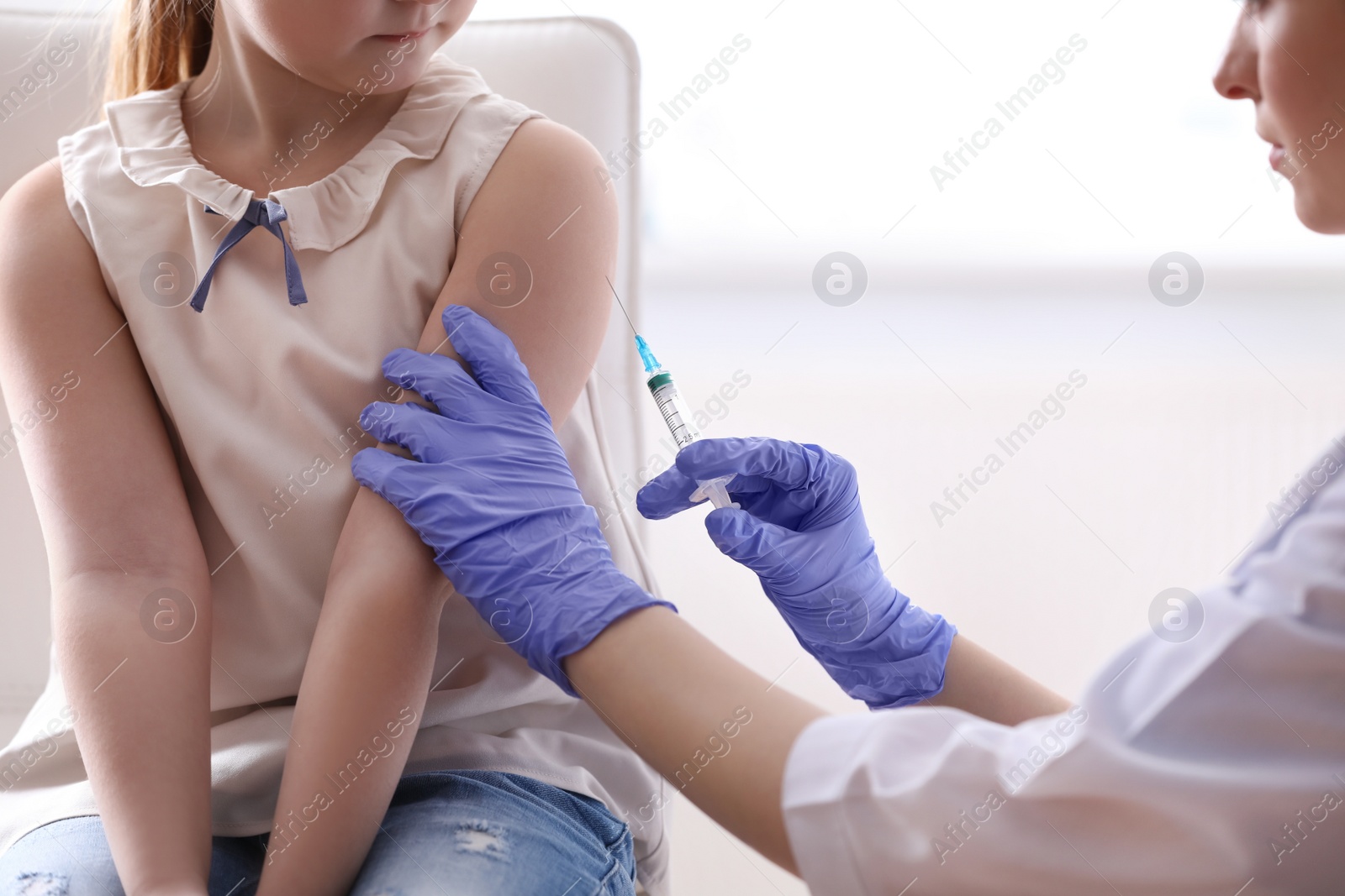 Photo of Little girl receiving chickenpox vaccination in clinic. Varicella virus prevention