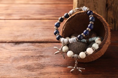 Stylish presentation of beautiful bracelets with gemstones on wooden table, closeup. Space for text