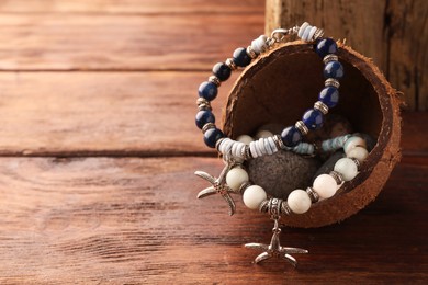 Photo of Stylish presentation of beautiful bracelets with gemstones on wooden table, closeup. Space for text