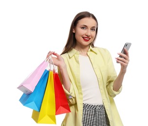 Photo of Stylish young woman with shopping bags and smartphone white background