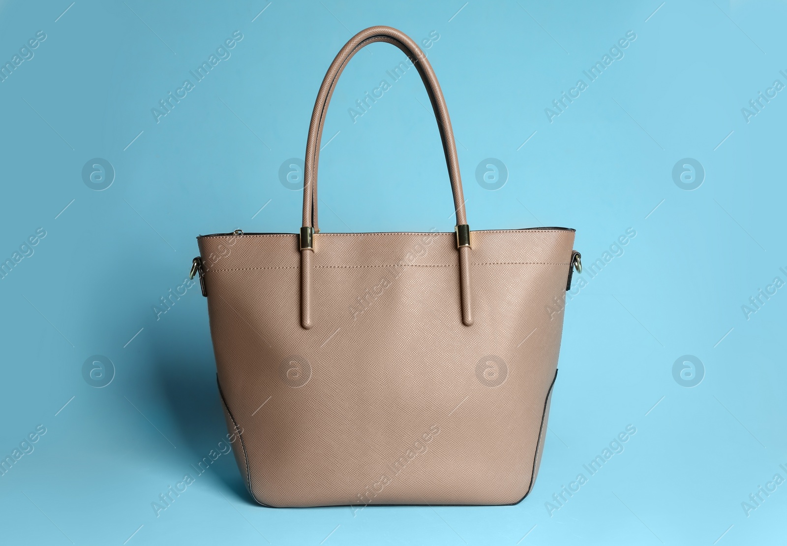 Photo of Stylish woman's bag on light blue background