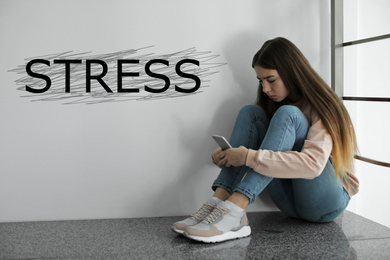 Image of Depressed young girl sitting on floor indoors and word STRESS
