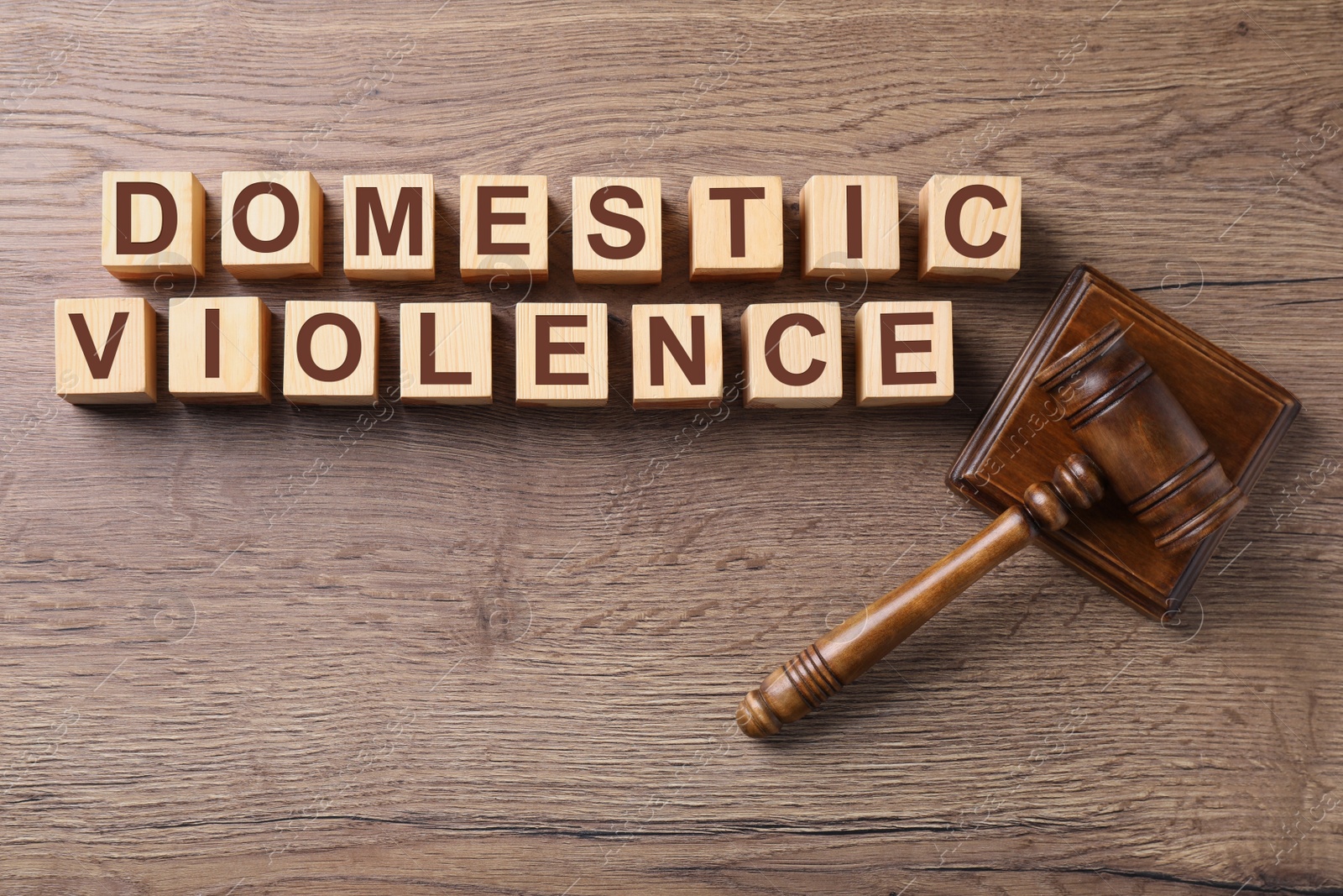 Image of Wooden cubes with words DOMESTIC VIOLENCE and gavel on table, flat lay