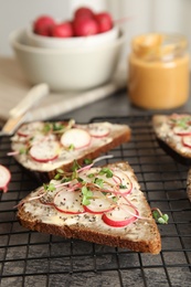 Tasty toasts with radishes, sprouts and chia seeds on cooling grate