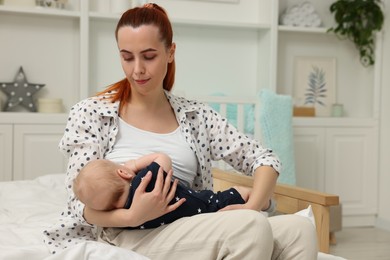Photo of Mother breastfeeding her baby at home, space for text