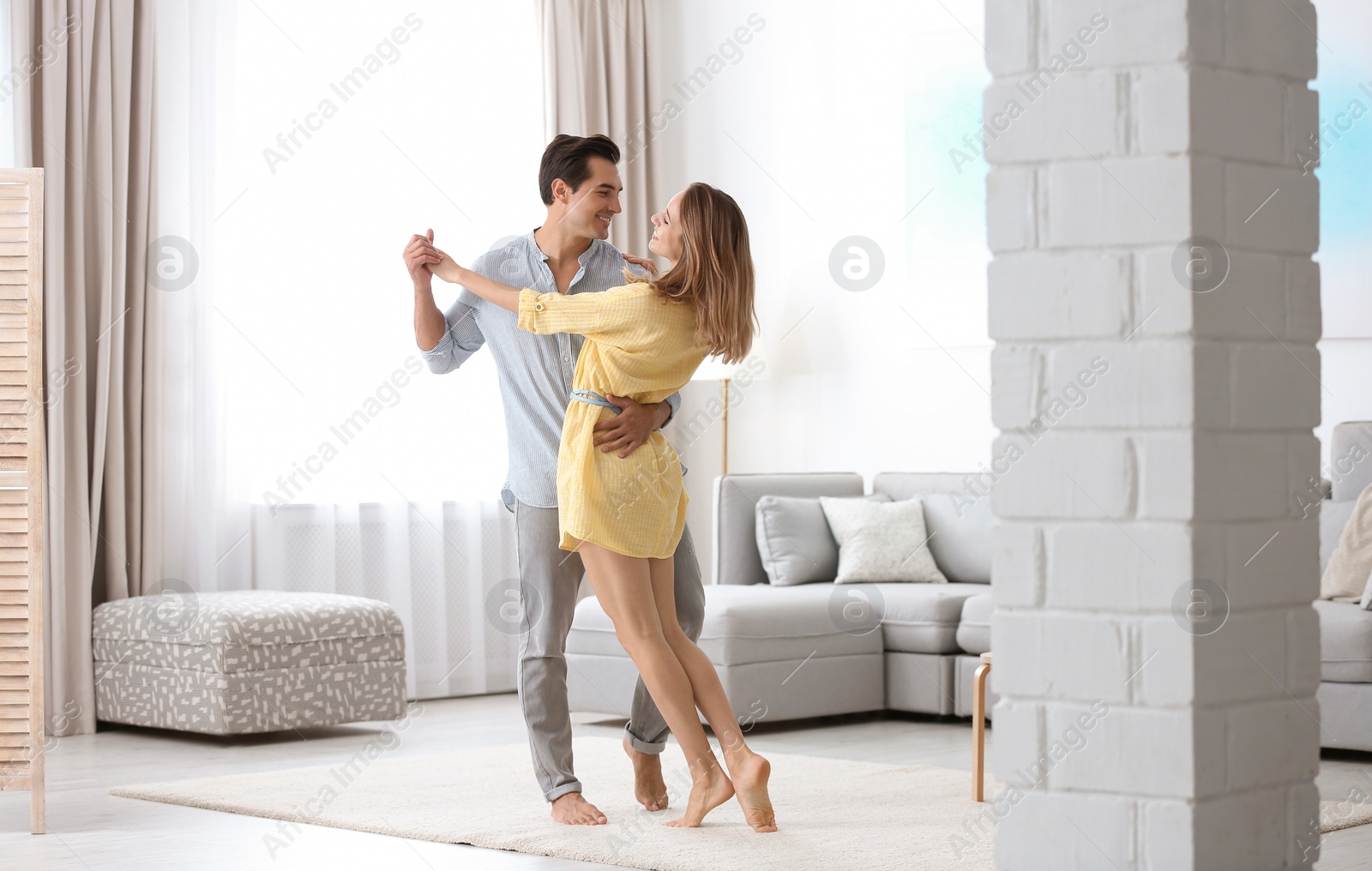 Photo of Beautiful young couple dancing in living at home