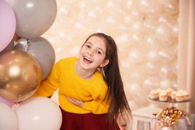 Portrait of laughing girl with balloons in beautifully decorated room