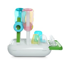Photo of Dryer with baby bottles and nipples after sterilization on light grey table against white background