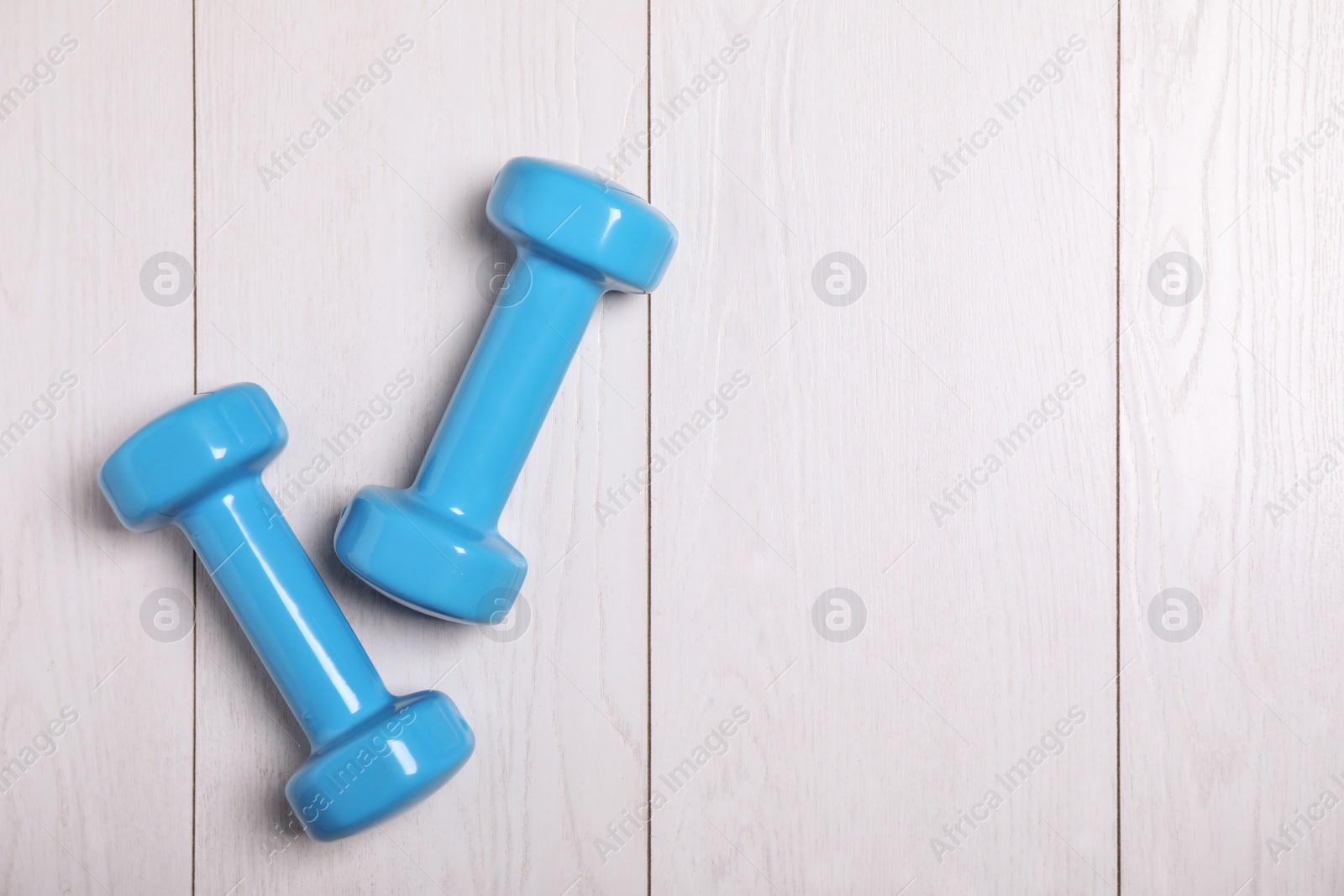 Photo of Vinyl dumbbells and space for text on wooden background, flat lay