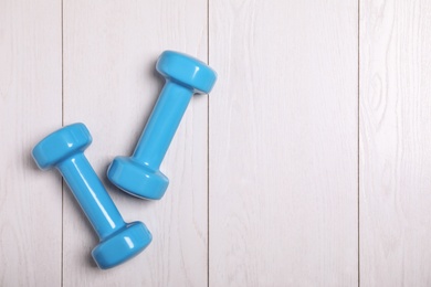 Vinyl dumbbells and space for text on wooden background, flat lay