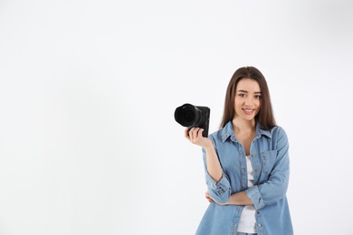 Female photographer with camera on light background
