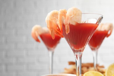 Photo of Tasty shrimp cocktail with sauce in glasses on table, closeup. Space for text