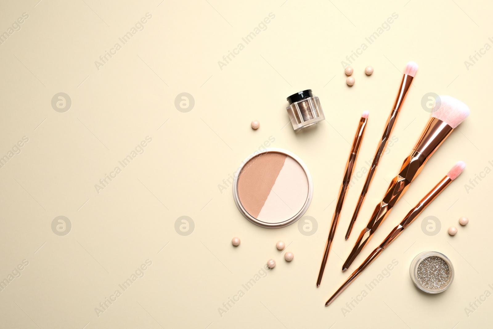 Photo of Flat lay composition with makeup brushes on beige background. Space for text