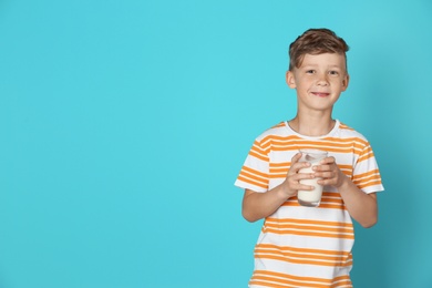 Photo of Adorable little boy with glass of milk on color background
