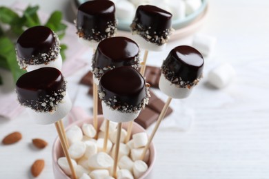 Photo of Delicious marshmallows covered with chocolate on sticks, closeup