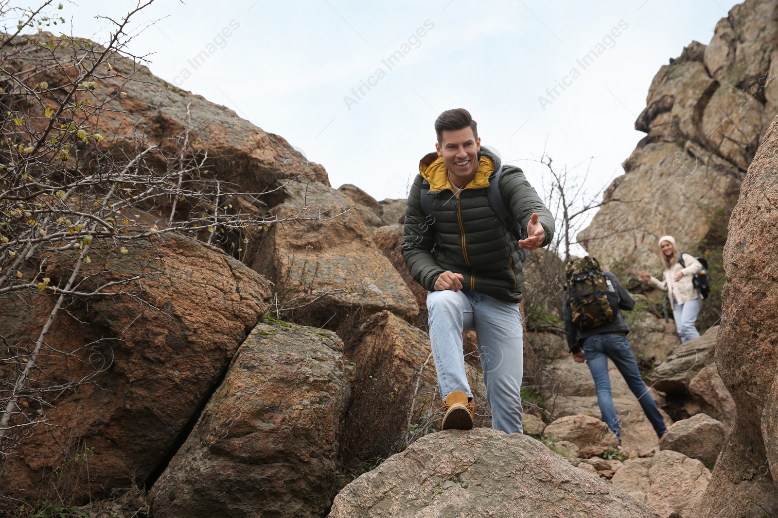 Photo of Group of hikers with backpacks climbing up mountains