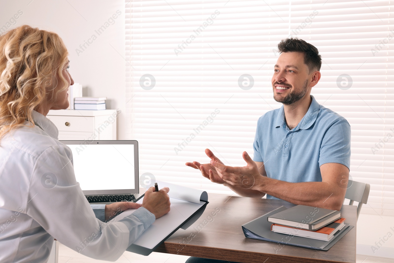 Photo of Doctor consulting patient at table in clinic