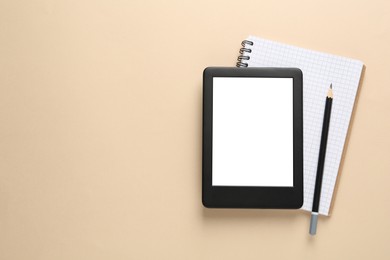 Photo of Modern e-book reader, notebook and pencil on beige background, top view. Space for text