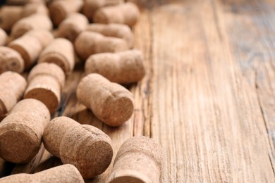 Photo of Sparkling wine bottle corks on wooden table, closeup. Space for text