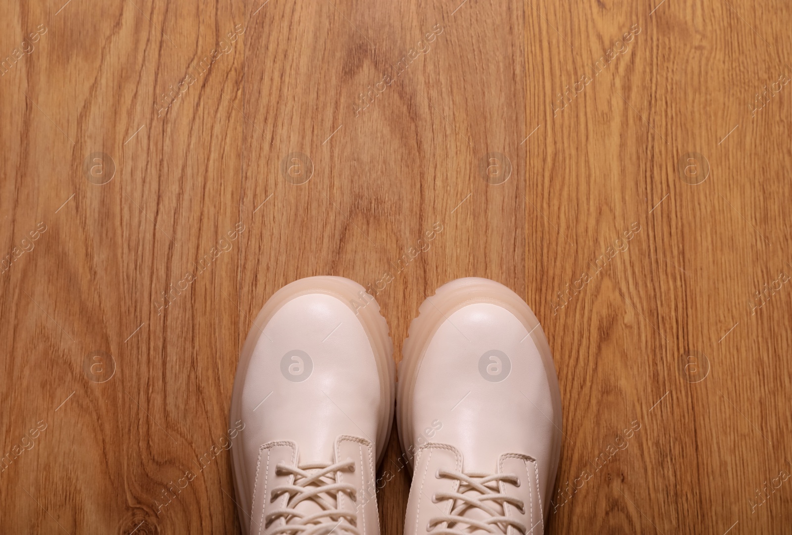 Photo of Pair of stylish beige leather shoes on wooden floor, top view. Space for text