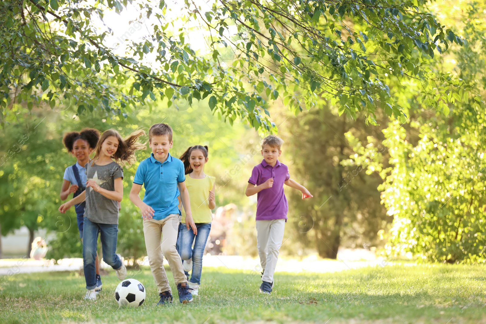 Photo of Cute little children playing with ball outdoors on sunny day