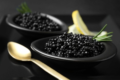 Bowls with black caviar on plate, closeup