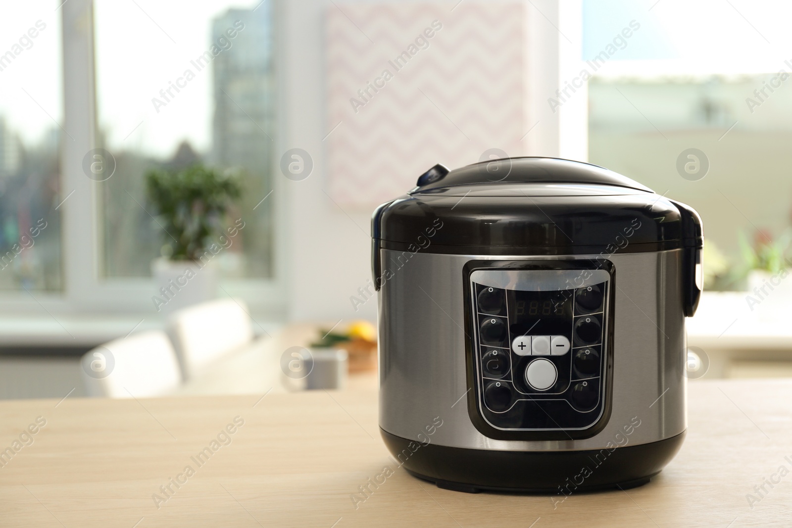 Photo of Modern multi cooker on table in kitchen. Space for text