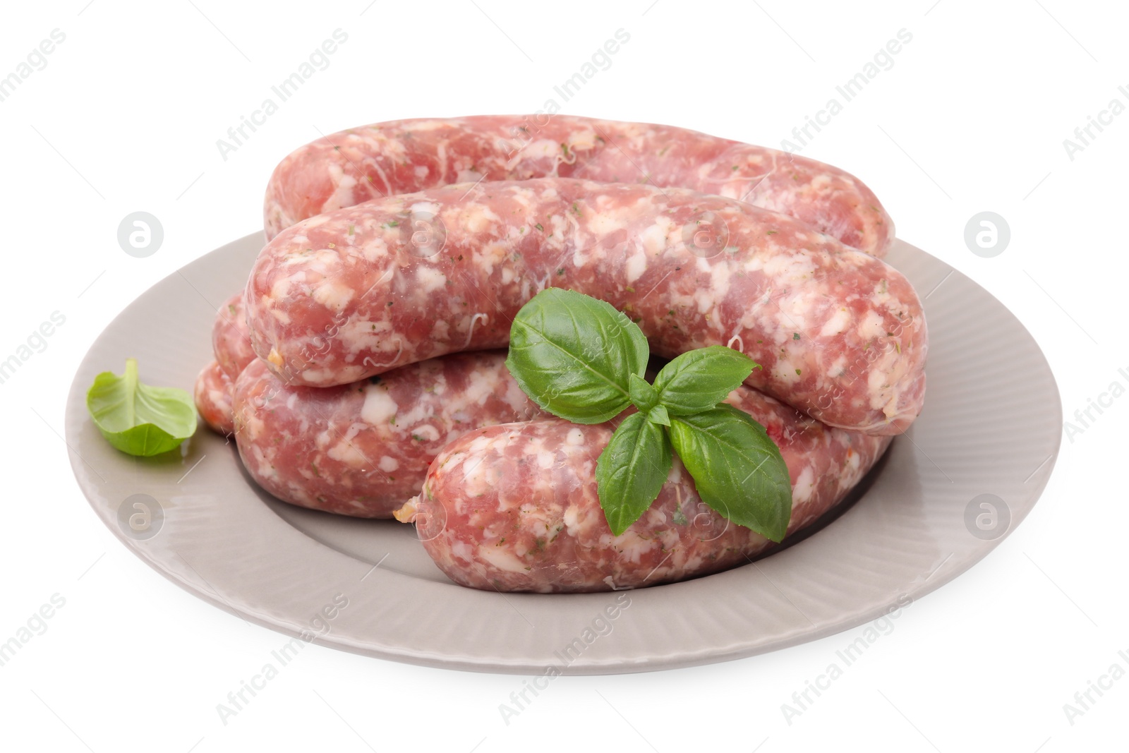 Photo of Plate of raw homemade sausages and basil leaves isolated on white