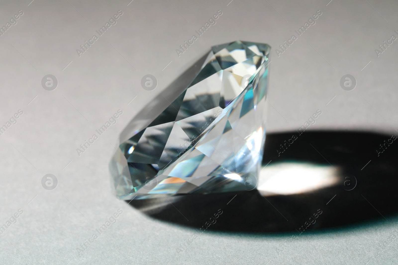 Photo of Beautiful dazzling diamond on grey background, closeup