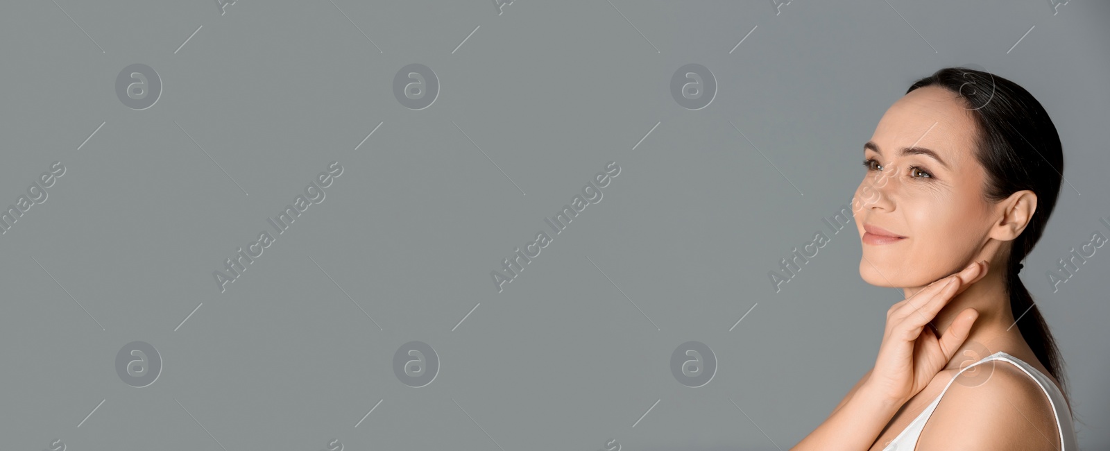 Image of Portrait of beautiful mature woman on grey background, space for text. Banner design