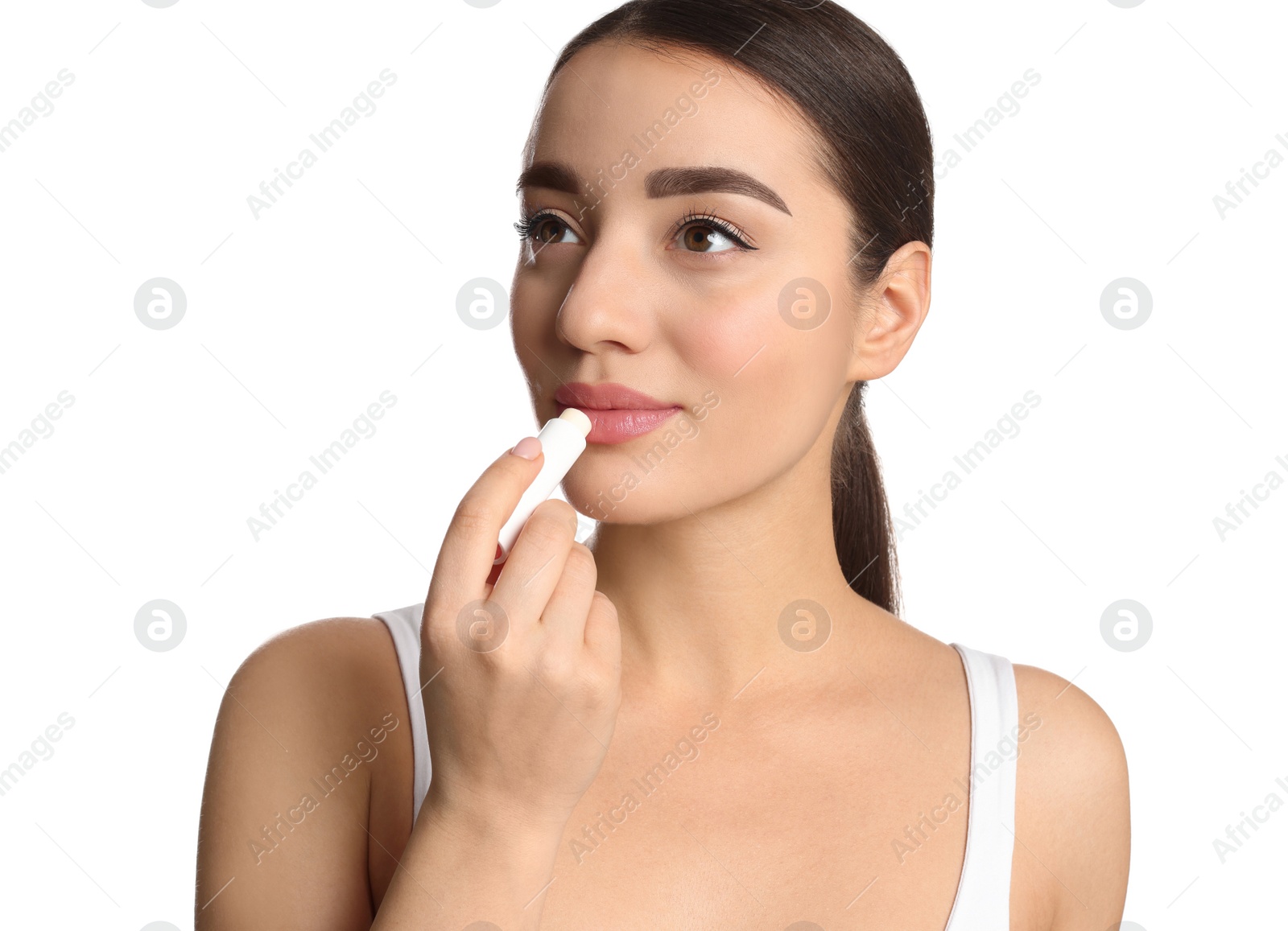 Photo of Young woman applying lip balm on white background