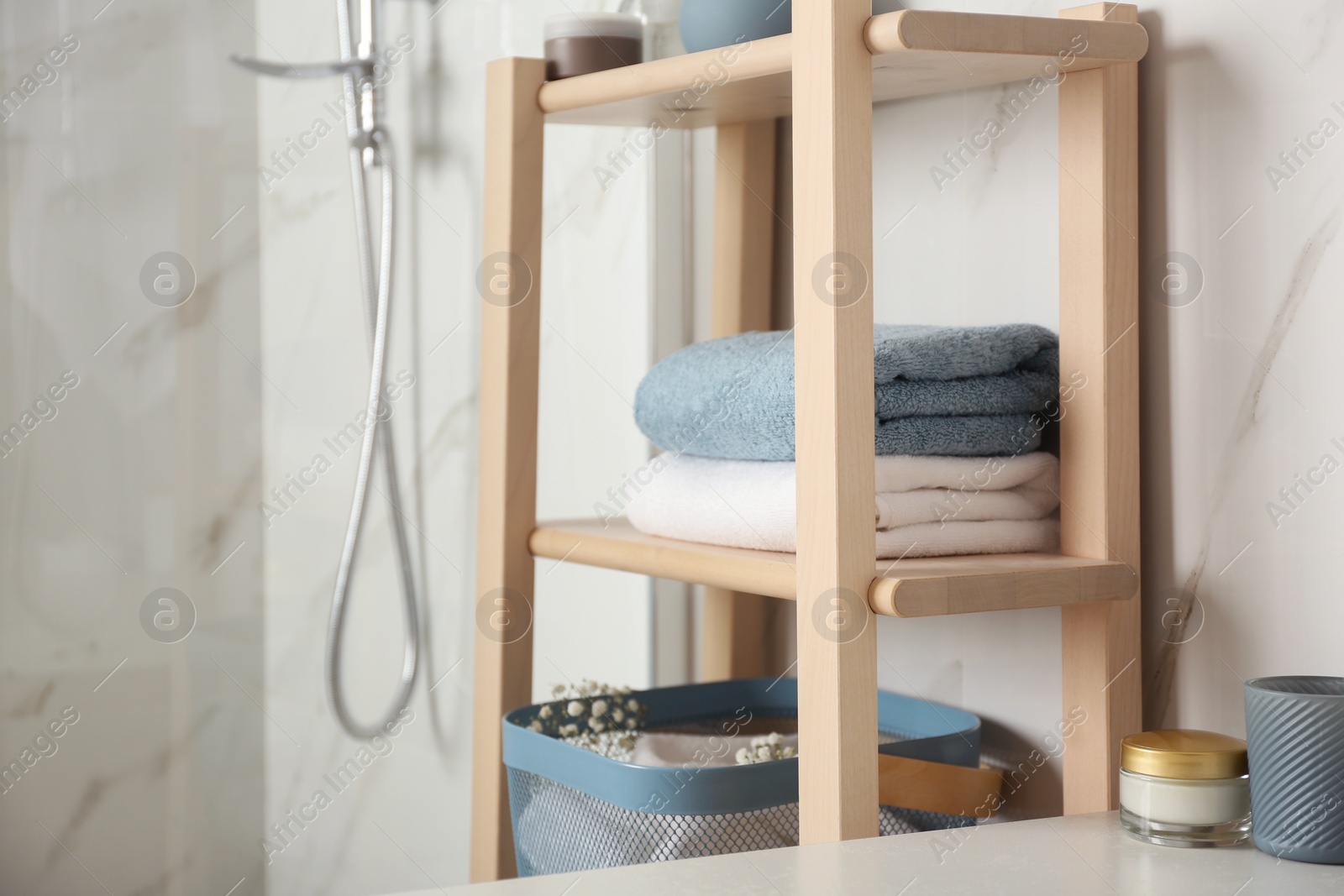 Photo of Shelving unit with clean towels in bathroom interior