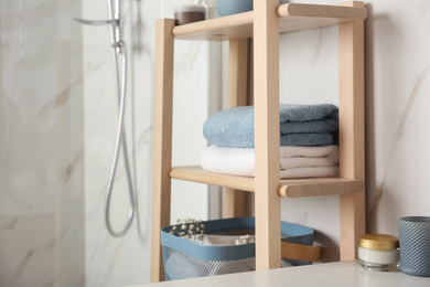 Shelving unit with clean towels in bathroom interior