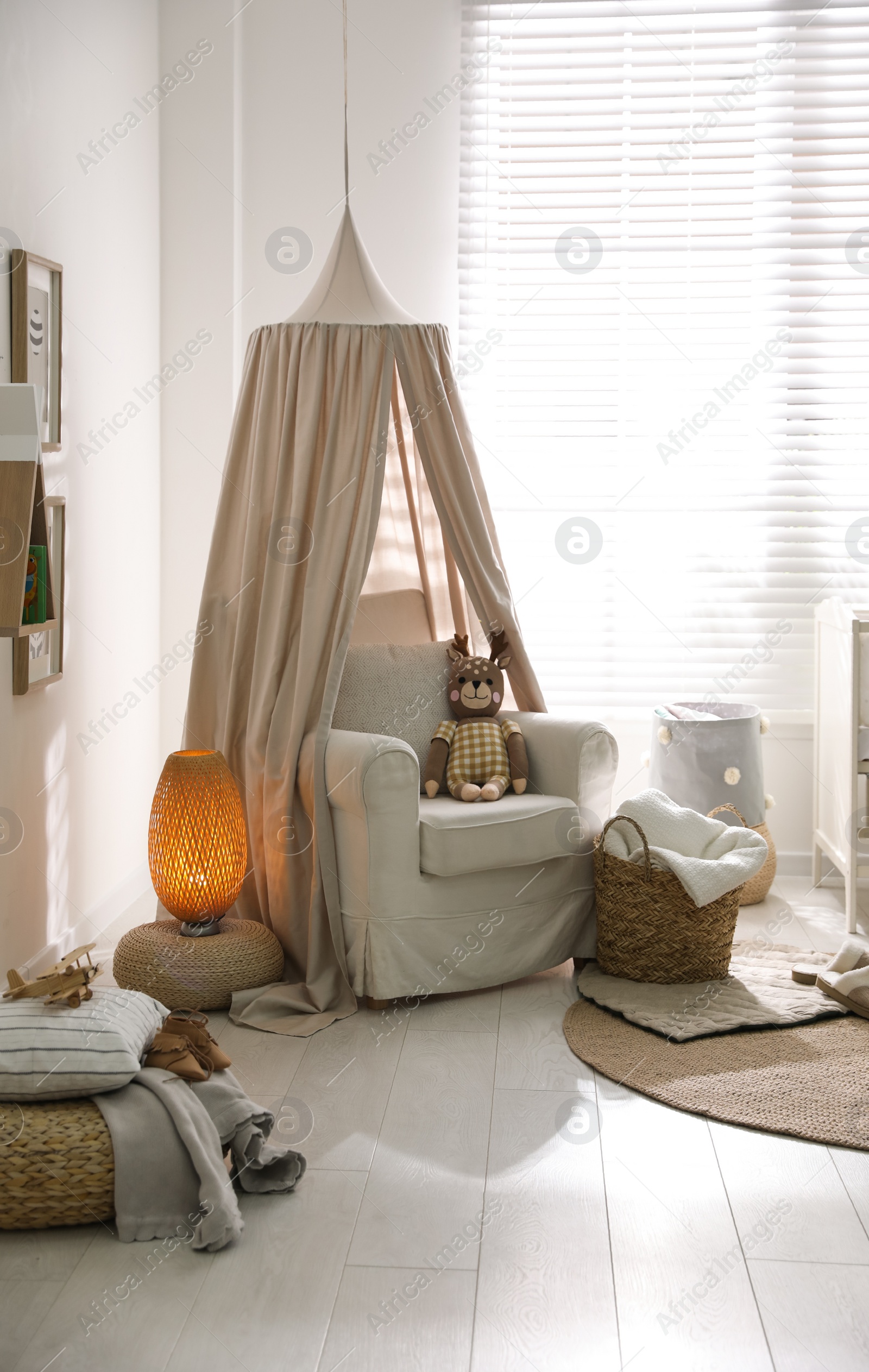 Photo of Stylish baby room interior with toys and comfortable armchair