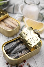 Open tin cans with mackerel fillets on light textured background
