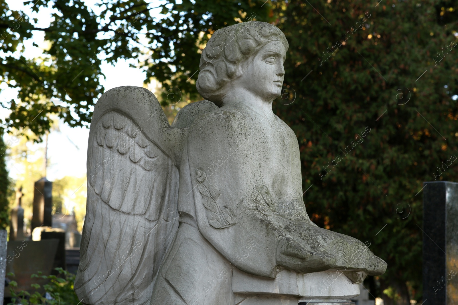 Photo of Beautiful statue of angel at cemetery. Religious symbol