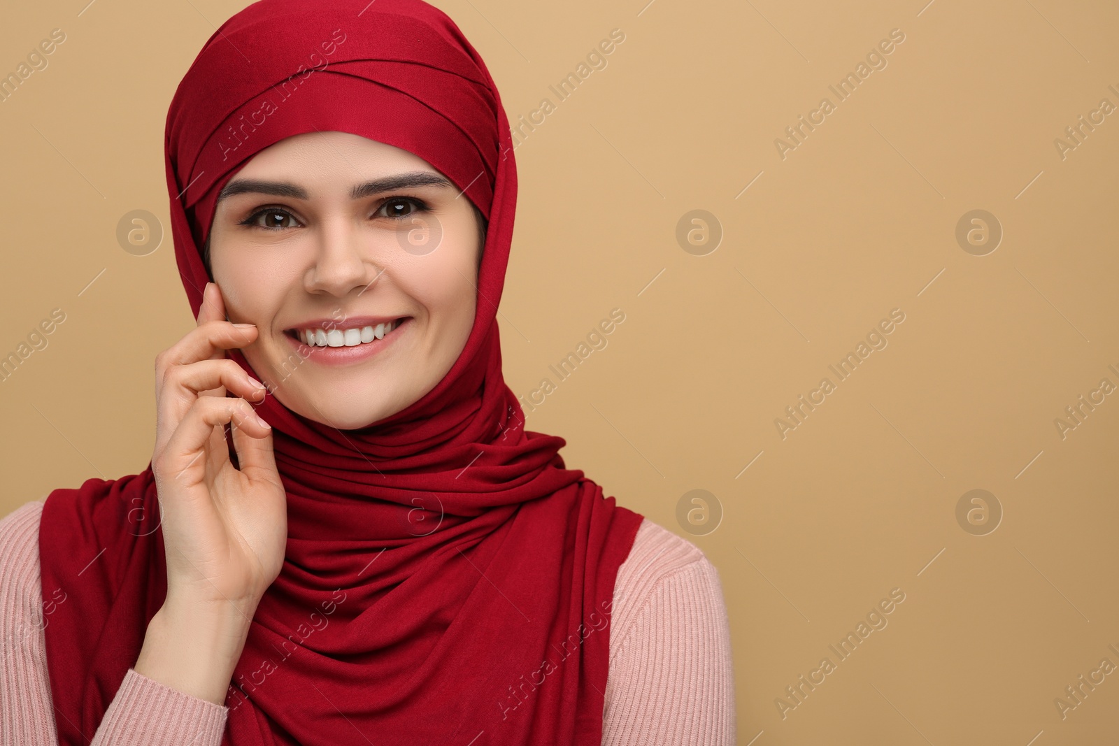 Photo of Portrait of Muslim woman in hijab on beige background, space for text