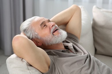 Portrait of senior man on sofa at home