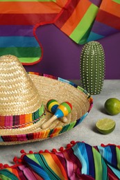 Composition with Mexican sombrero hat and maracas on grey table