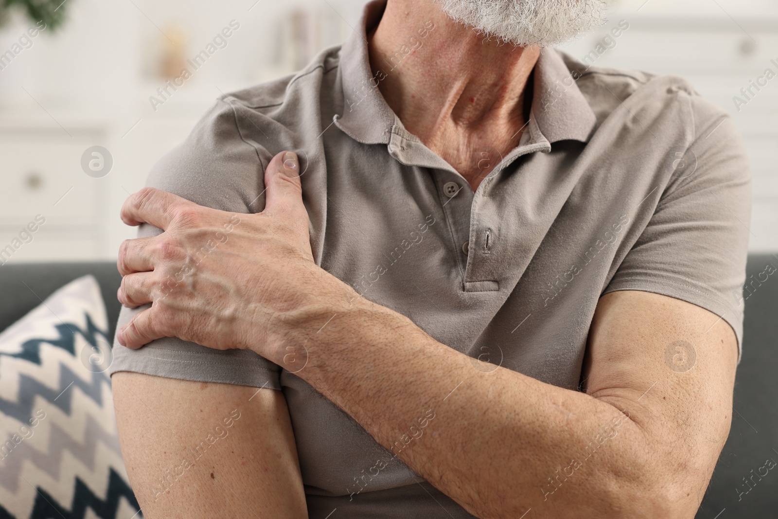 Photo of Arthritis symptoms. Man suffering from pain in shoulder at home, closeup