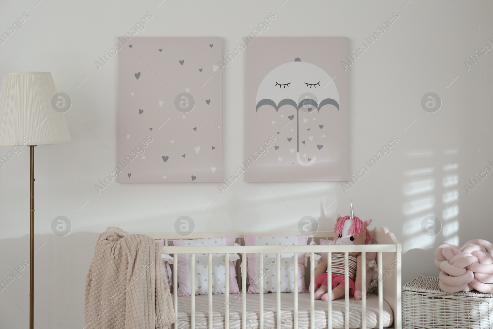 Photo of Stylish baby room interior with crib and cute wall art