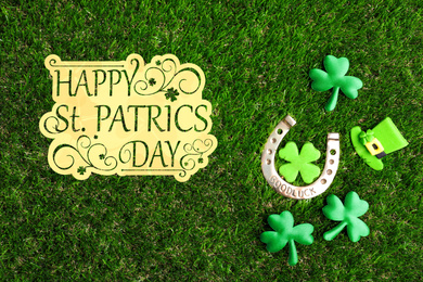 Image of Flat lay composition with horseshoe on green grass. St. Patrick's Day celebration