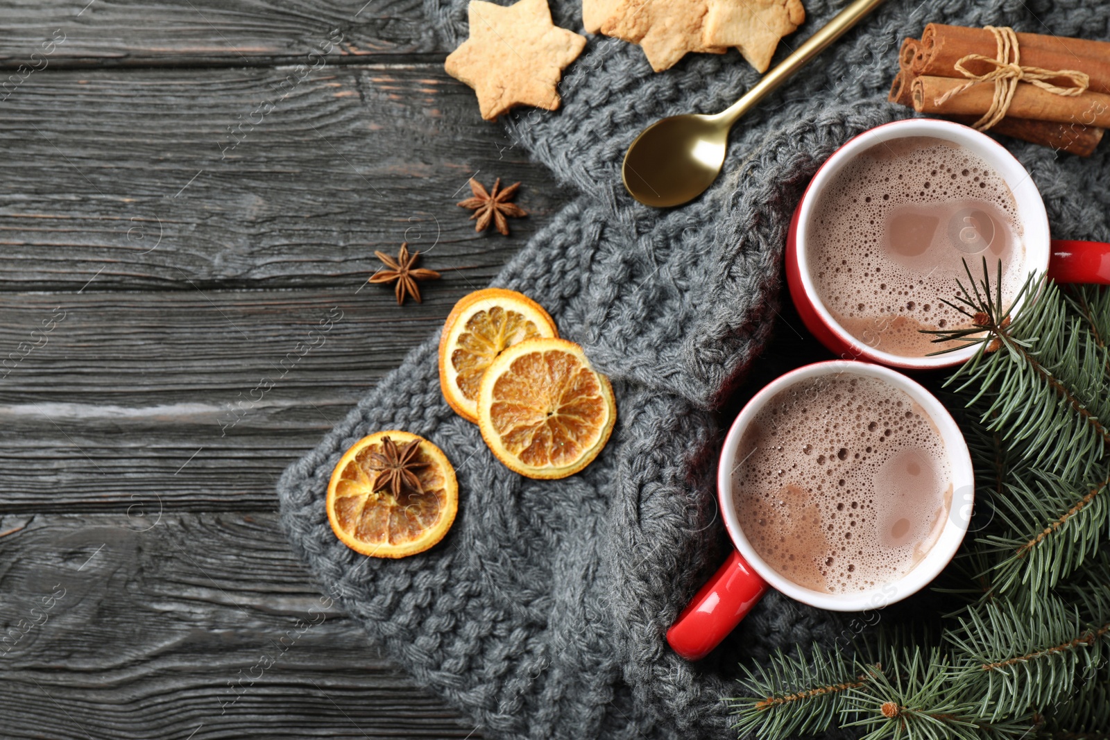 Photo of Flat lay composition with cups of tasty cocoa on black wooden table