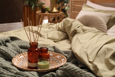 Photo of Reed freshener and candles on bed indoors