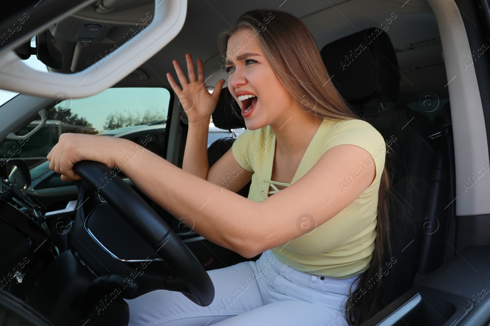Photo of Emotional woman in car. Aggressive driving behavior