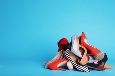 Photo of Heap of different shoes on color background. Space for text