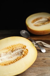 Half of tasty ripe melon on wooden table, closeup