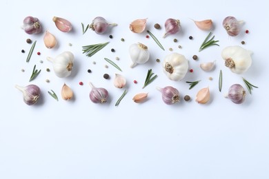 Photo of Fresh garlic, rosemary and peppercorns on white background, flat lay. Space for text