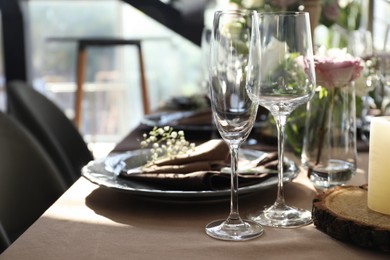 Photo of Festive table setting with beautiful tableware and floral decor in restaurant