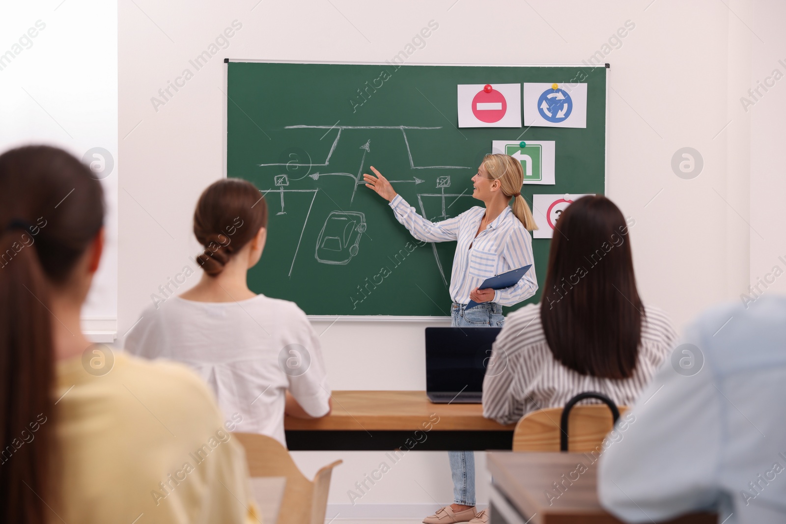 Photo of Teacher explaining traffic rules to audience during lesson in driving school